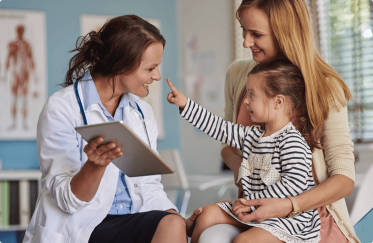 Doctor using ipad app to show information to mother and daughter.